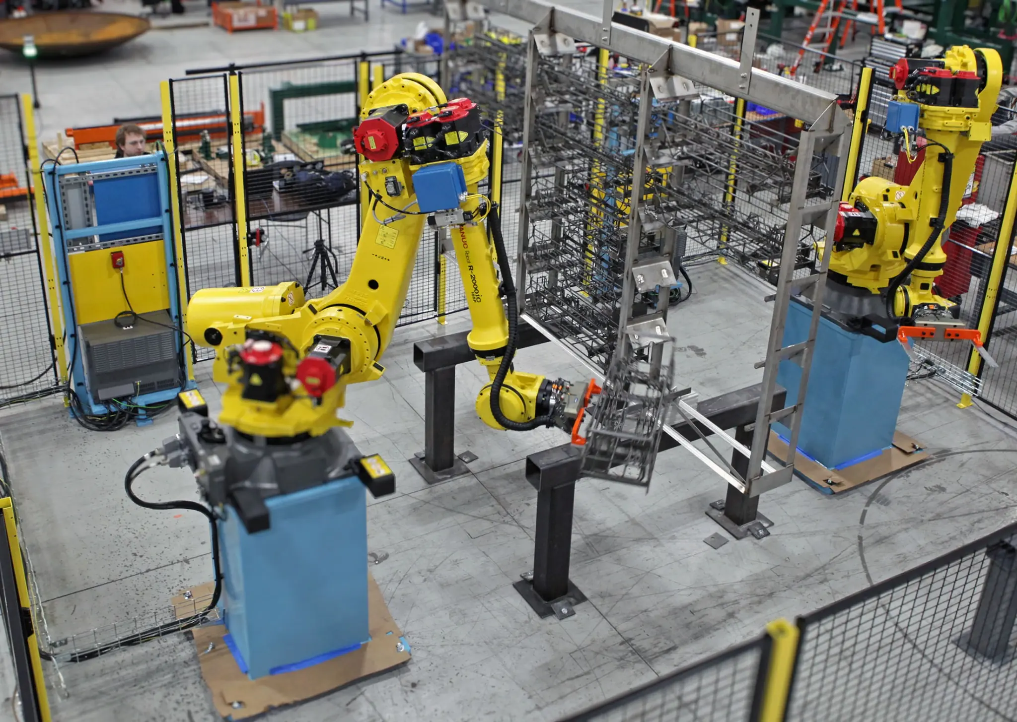 Жёлтые промышленные роботы в производственной ячейке